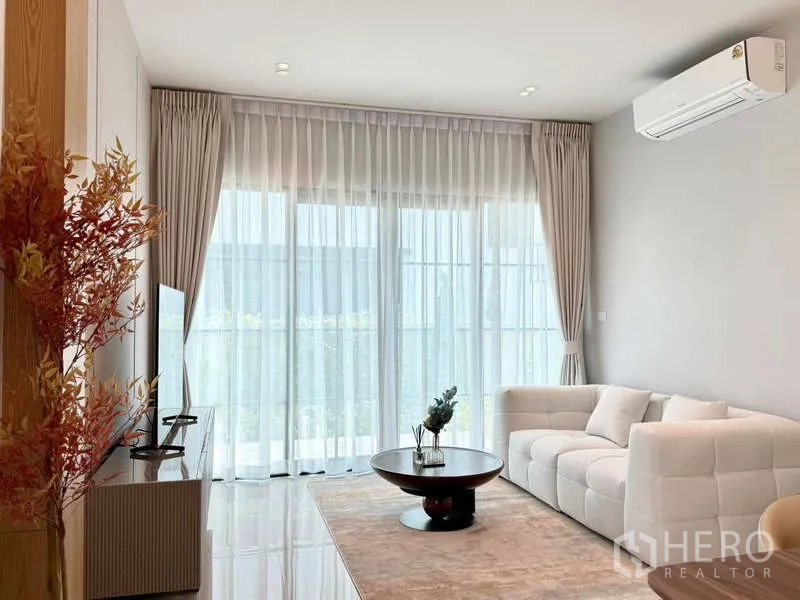 独立式住宅 出租或出售在Bang Phli, Samut Prakan - 客廳配白色沙發、推拉落地門、紗簾與空調。