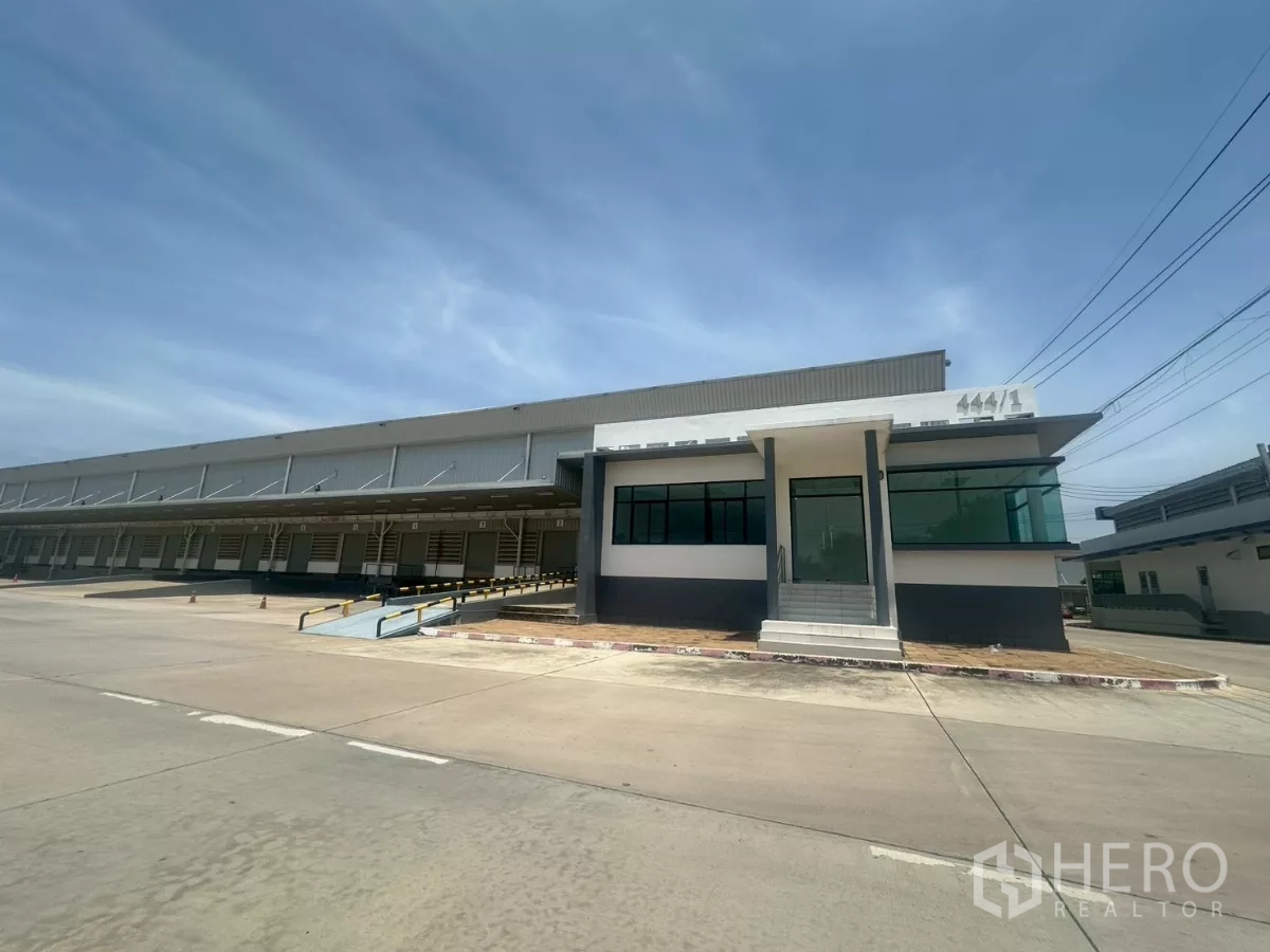 Warehouse for rent in Bang Phli, Samut Prakan - Front view of warehouse office pavilion beside multiple loading docks and canopy.
