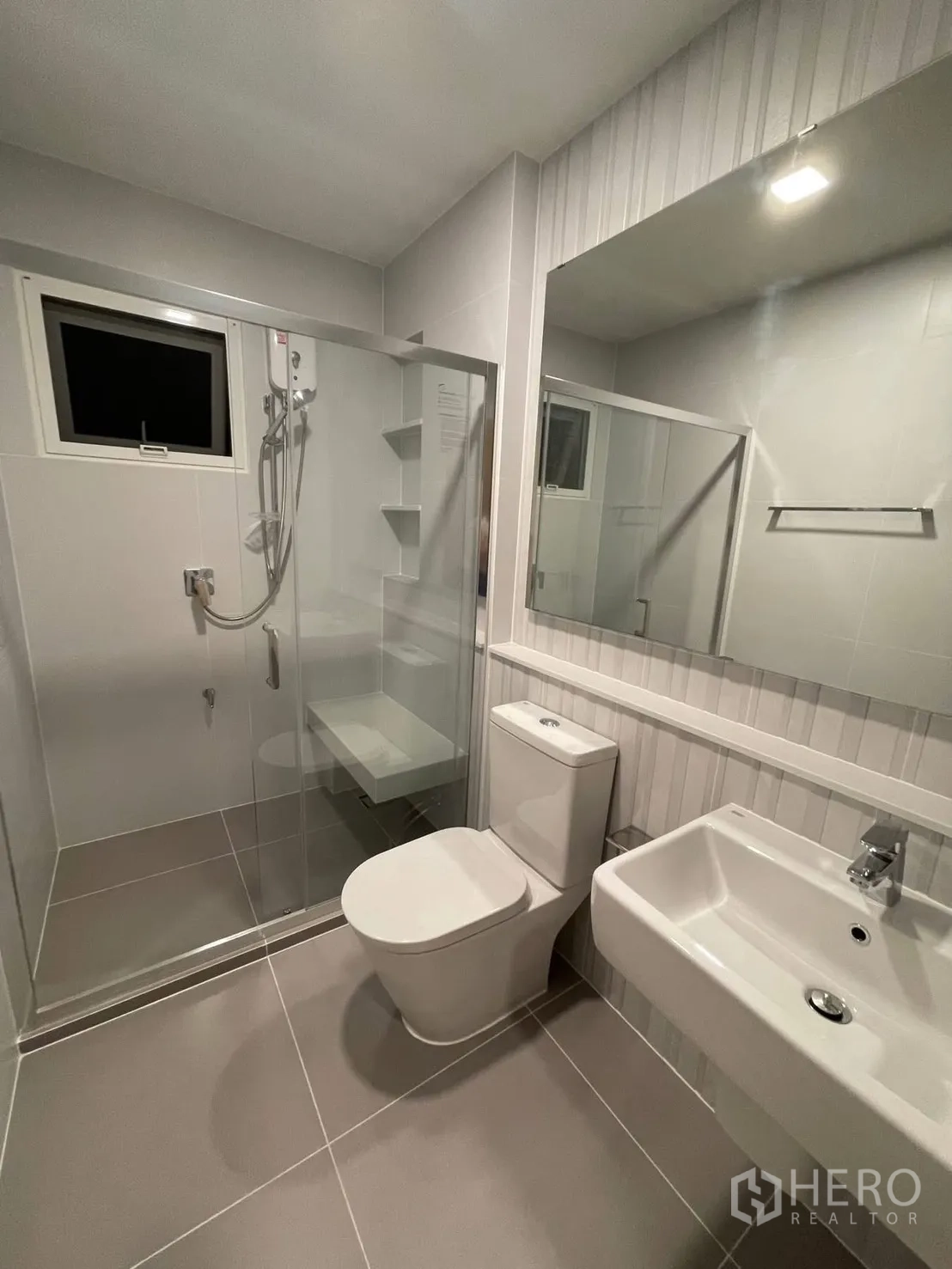 Detached House for rent in Prawet, Bangkok - Contemporary bathroom with glass shower, toilet, and sink.