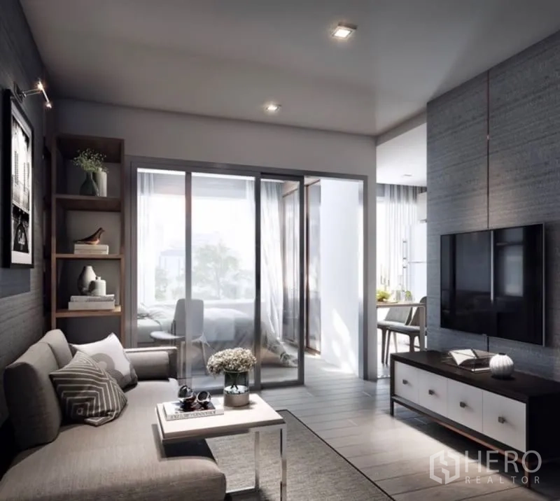 公寓 出售在Phra Khanong, Bangkok - 素坤逸64公寓明亮客厅，配沙发、电视墙与通往卧室和餐区的推拉玻璃门。