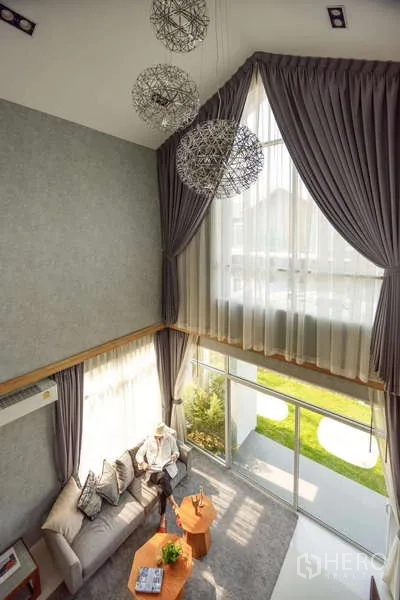 บ้าน ขายในLam Luk Ka, Pathum Thani - มุมมองจากชั้นลอยของห้องนั่งเล่น เพดานสูง ผ้าม่านยาว และโคมไฟระย้า