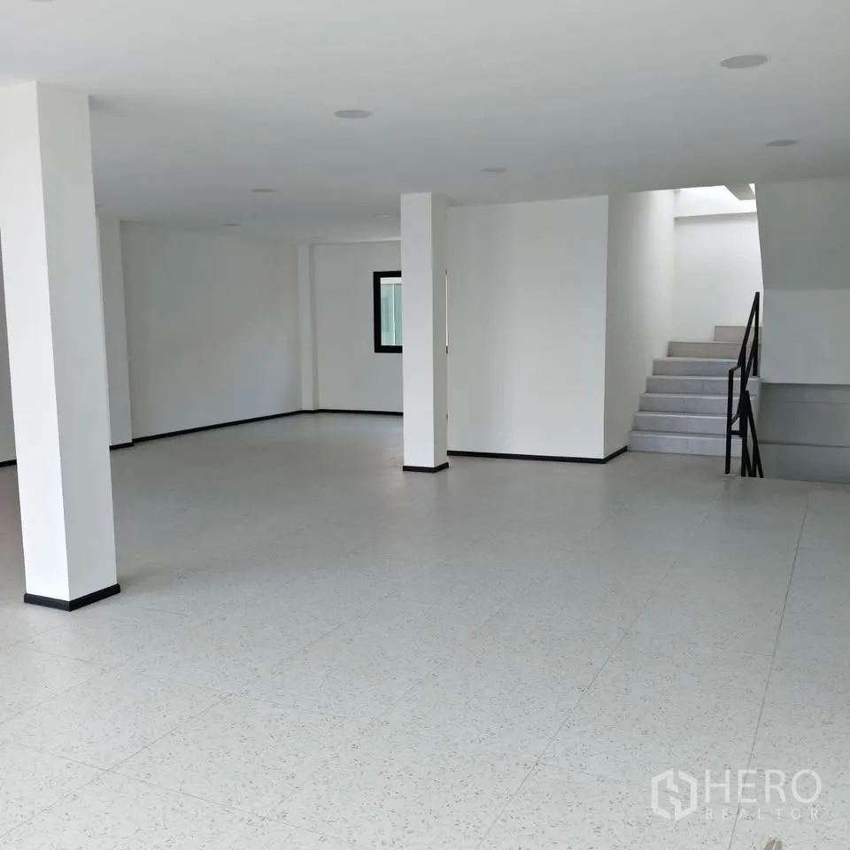 家庭办公室 for rent in Bang Na, Bangkok - 明亮的一层开放空间，白墙、地砖、立柱和楼梯。