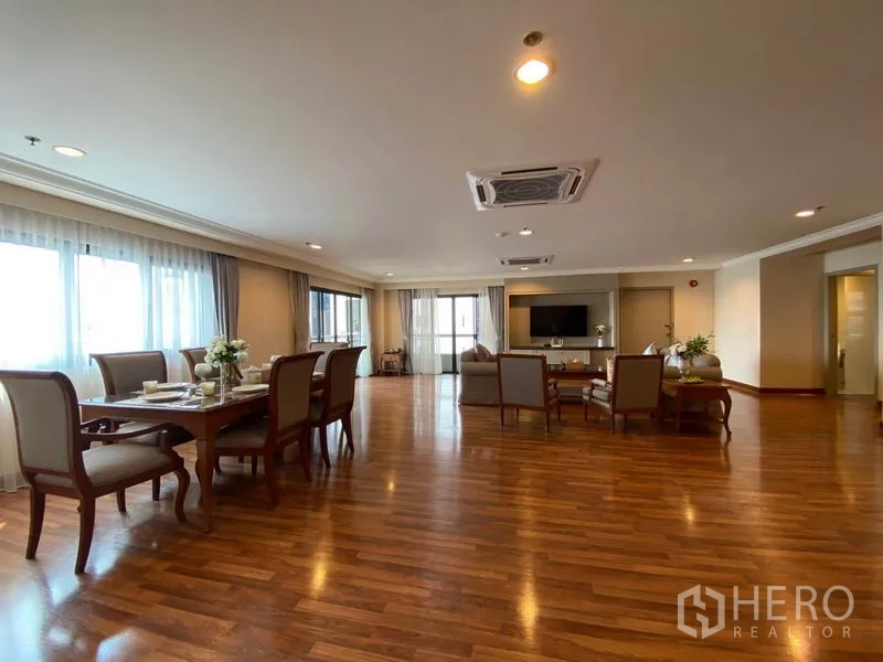 Condominium for rent in Watthana, Bangkok - Spacious open-plan living and dining area with hardwood floors, large windows, cassette air-con and TV wall.