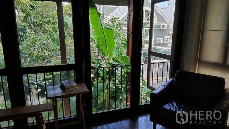Detached House for sale in Suan Luang, Bangkok - Balcony doors framing greenery and bringing daylight into the room.