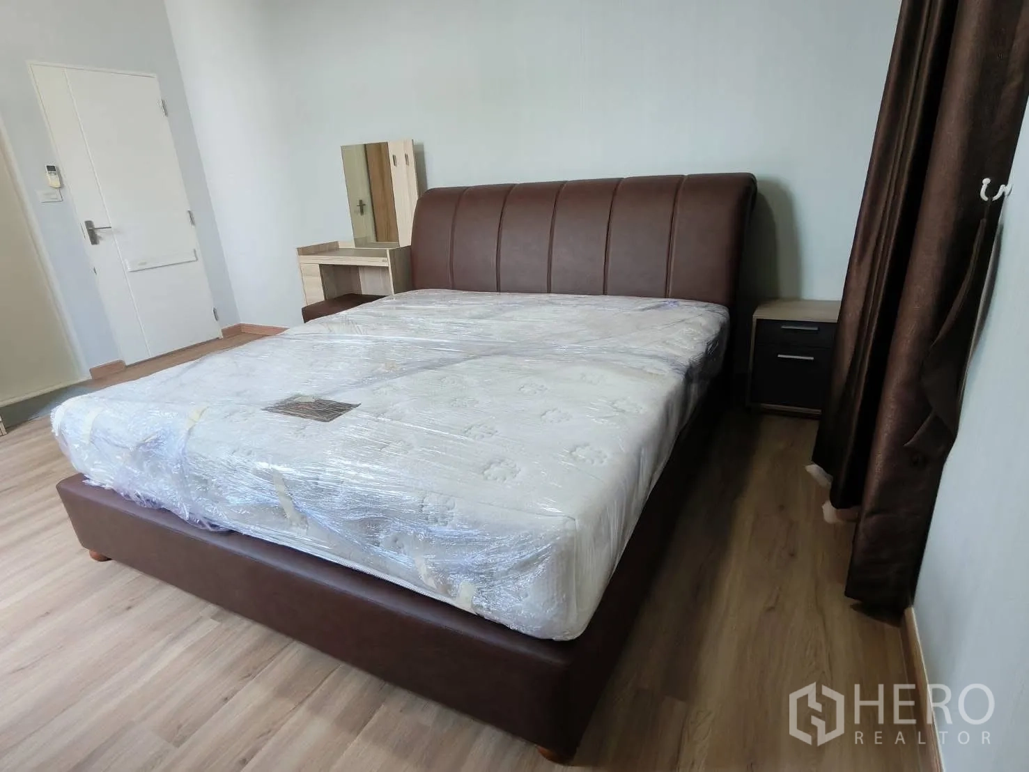 บ้านเดี่ยว for rent in Bang Phli, Samut Prakan - ห้องนอนสว่างพร้อมเตียงบุหนังสีน้ำตาล โต๊ะเครื่องแป้ง และโต๊ะข้าง