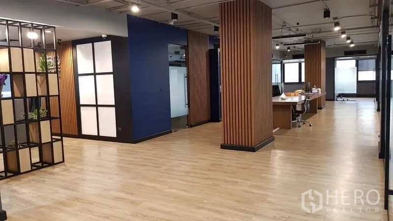 สำนักงาน ให้เช่าในKhlong Toei, Bangkok - พื้นที่ทำงานแบบเปิดโล่ง มีเสาไม้ระแนง ไฟเพดาน และโต๊ะแชร์บนพื้นไม้โทนอ่อน.