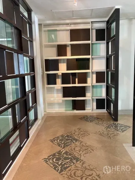 Office Space for rent in Khlong Toei, Bangkok - Decorative shelving wall with mixed glass and wood panels and patterned floor tiles.