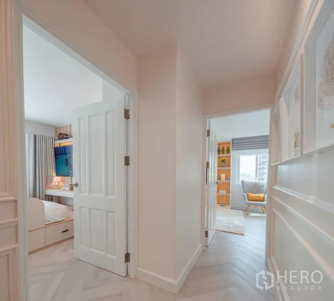 Condominium for sale in Yan Nawa, Bangkok - Hallway opening to two bedrooms with white double doors and city light beyond.