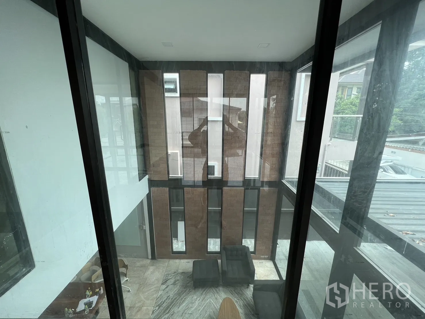 บ้าน ให้เช่าหรือขายในPhra Khanong, Bangkok - มองลงจากชั้นบนสู่ห้องนั่งเล่นเพดานสูงและผนังอิฐโชว์