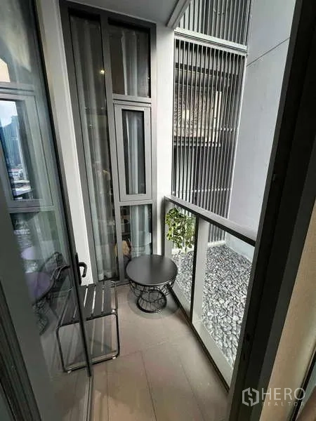 公寓 出租在Bang Rak, Bangkok - 小阳台，配椅子与边几，临建筑格栅景