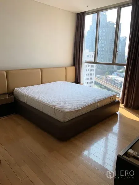 Condominium for rent in Watthana, Bangkok - Second bedroom with platform bed, corner windows and urban views.