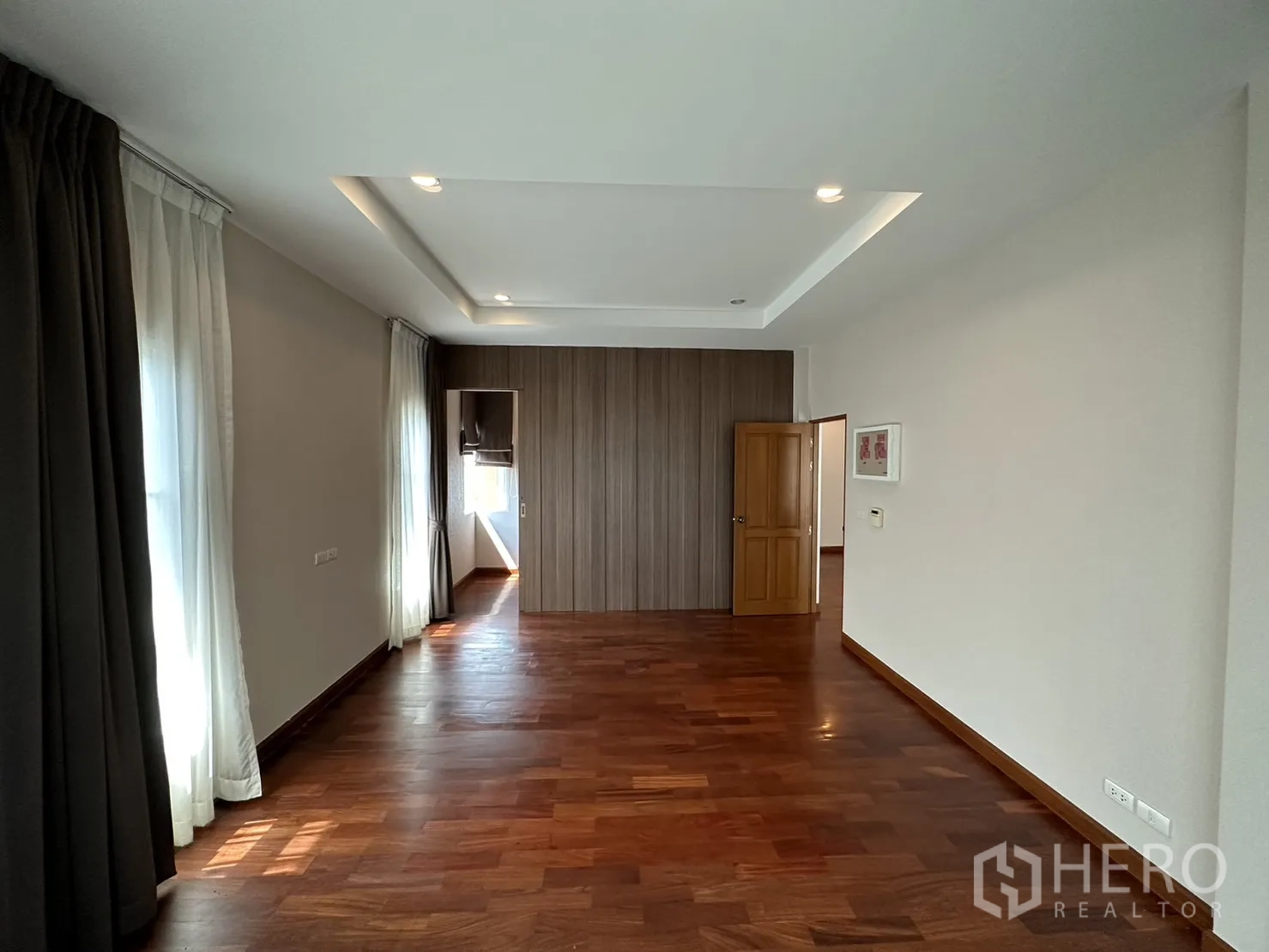 Detached House for rent or sale in Pak Kret, Nonthaburi - Sunlit bedroom with tray ceiling, multiple windows and timber floors.