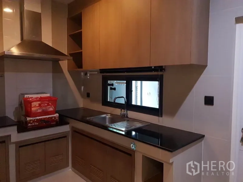 บ้าน ให้เช่าในBang Kapi, Bangkok - ครัวแยก เคาน์เตอร์หินแกรนิต อ่างล้างจานคู่ ตู้ลายไม้ และหน้าต่าง.