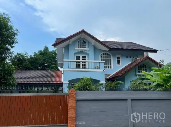 Detached House for rent in Bang Na, Bangkok - Close-up of the blue two-storey house with white balcony and arched windows