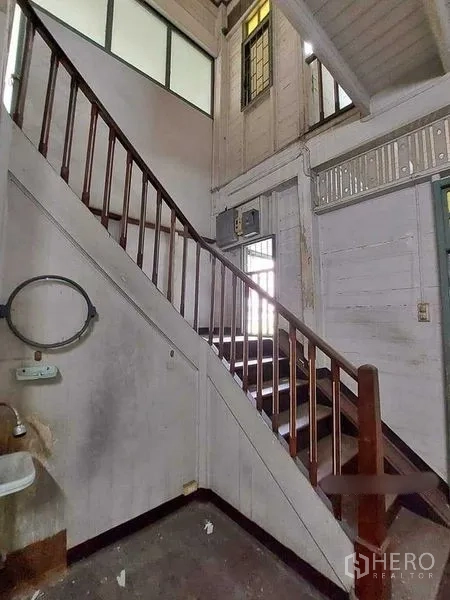 Detached House for rent in Bang Rak, Bangkok - Close view of timber stairs, high walls, and clerestory windows in a vintage Thai house.