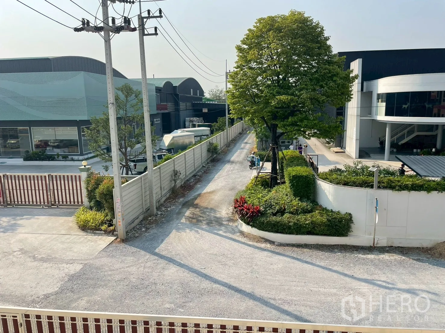 โรงงาน for sale in Sam Phran, Nakhon Pathom - มุมมองตามถนนโครงการ มีอาคารอุตสาหกรรม ประตูรั้ว และต้นไม้