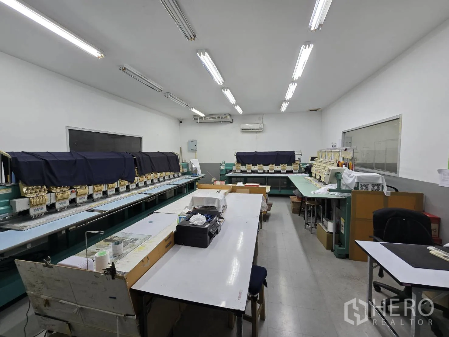 Factory for rent in Sam Phran, Nakhon Pathom - Embroidery room housing multiple embroidery machines and work desks.