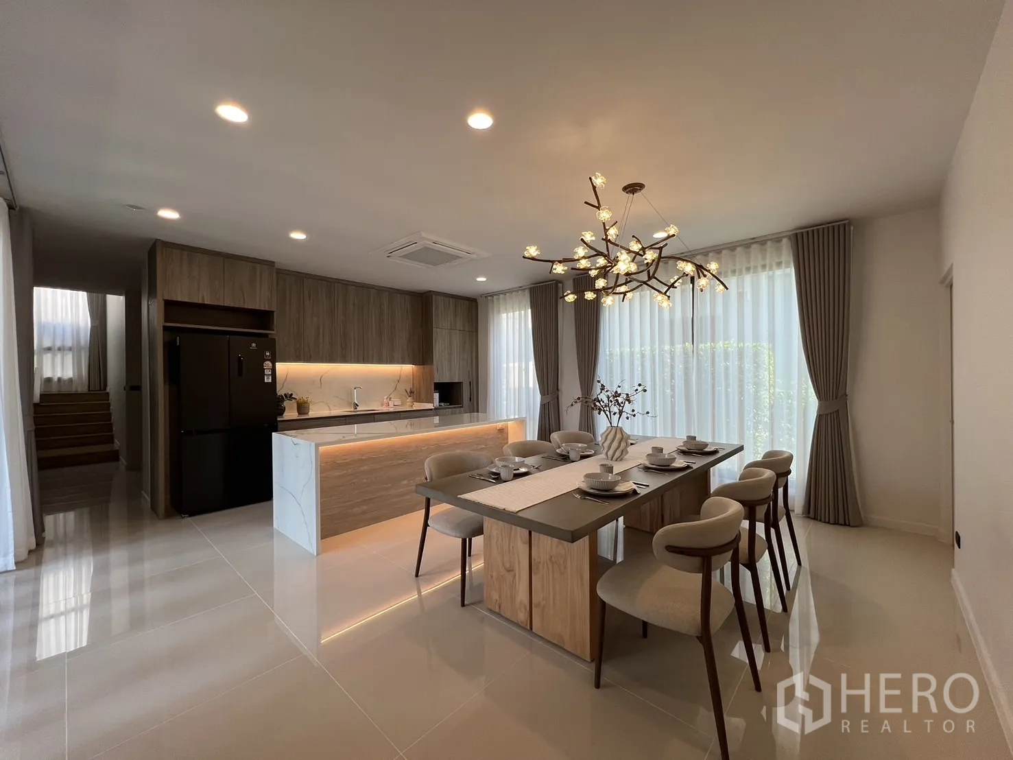 Detached House for rent or sale in Bang Kapi, Bangkok - Open-plan kitchen and dining with floor-to-ceiling windows and island lighting.