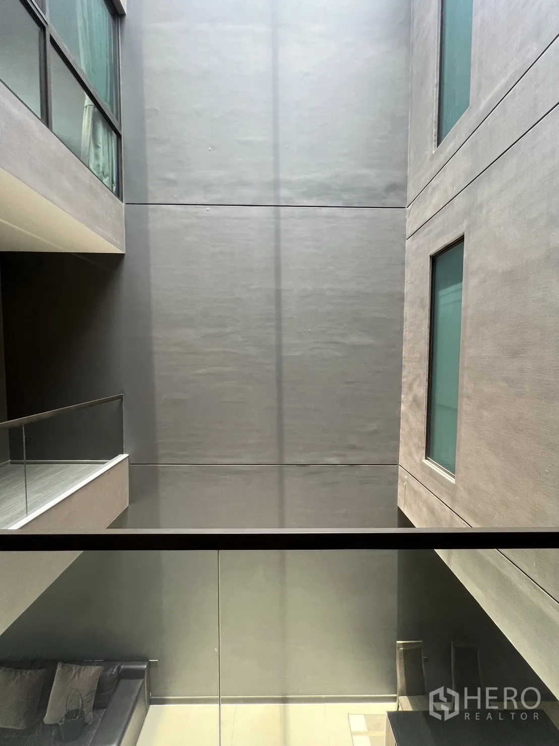 联排别墅 出租在Lat Phrao, Bangkok - 室內中庭，玻璃欄杆與磨砂窗，為各樓層引入自然光。