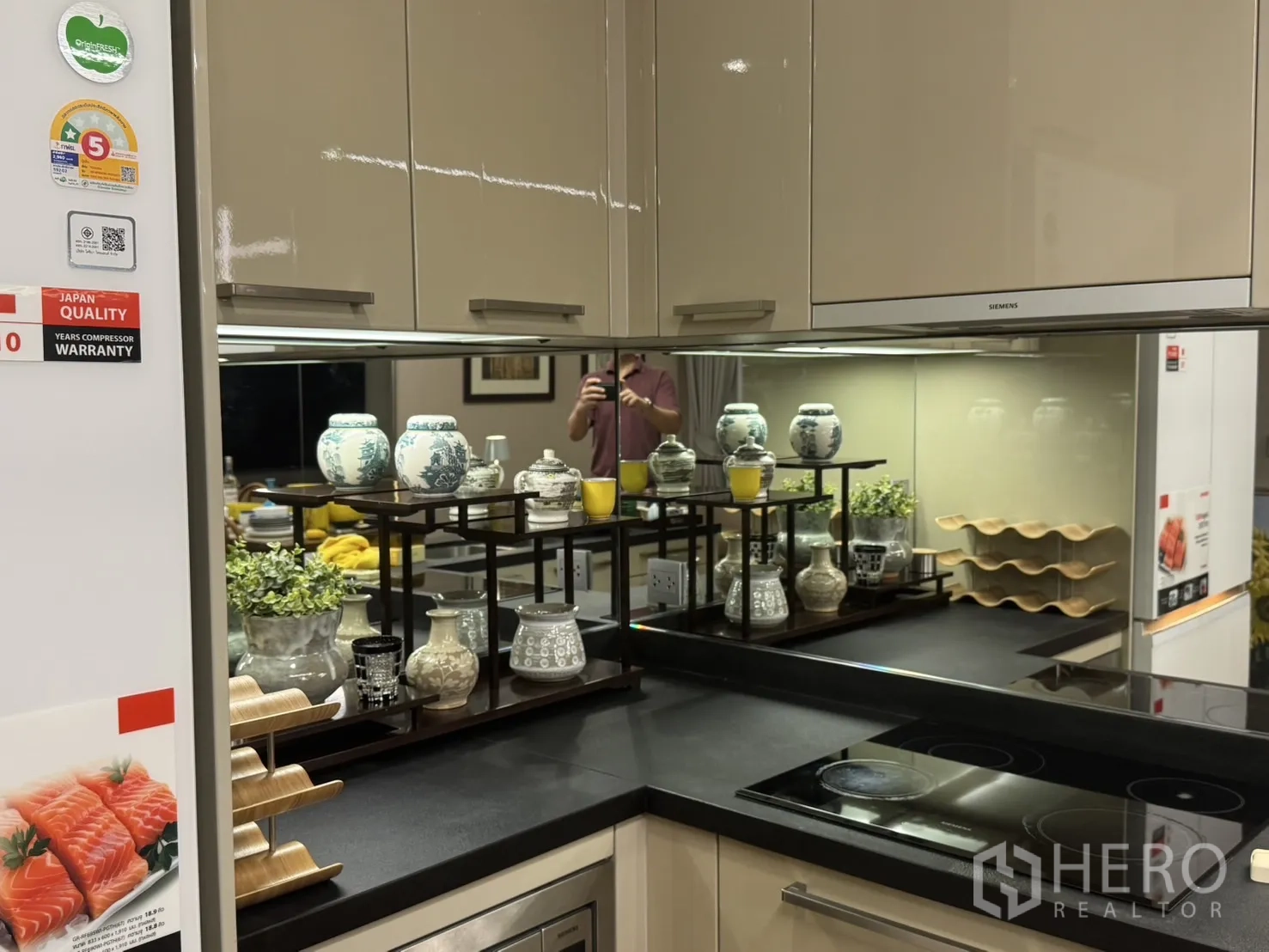 คอนโด ให้เช่าในWatthana, Bangkok - ภาพระยะใกล้ของครัวทันสมัย ผนังกระจกเงา เตาไฟฟ้า และชั้นวางของตกแต่ง