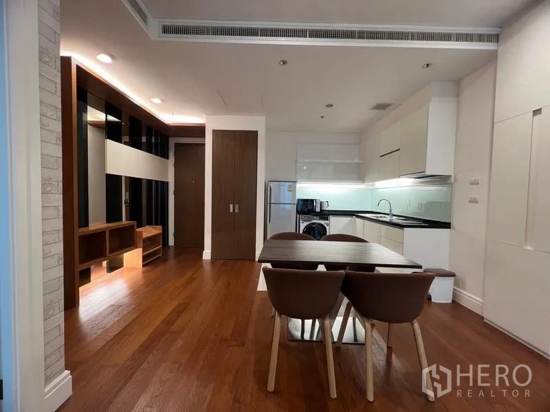 公寓 出租在Khlong Toei, Bangkok - 客餐厅一体的木地板空间，带内置柜体并连通厨房。