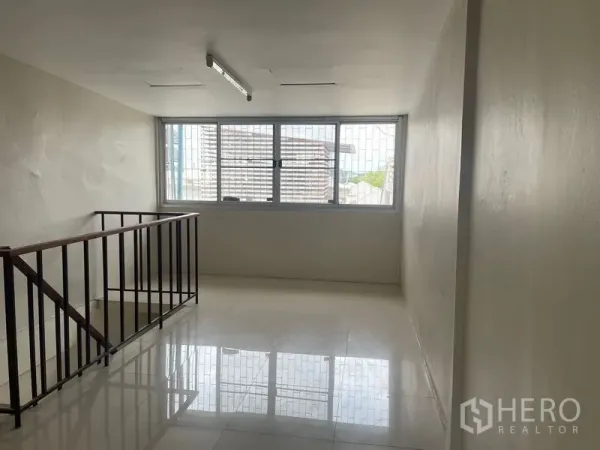 店屋 出租在Phra Khanong, Bangkok - 明亮夹层，设大窗与楼梯扶手。