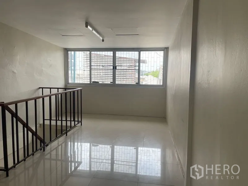 店屋 出租在Phra Khanong, Bangkok - 明亮夹层，设大窗与楼梯扶手。