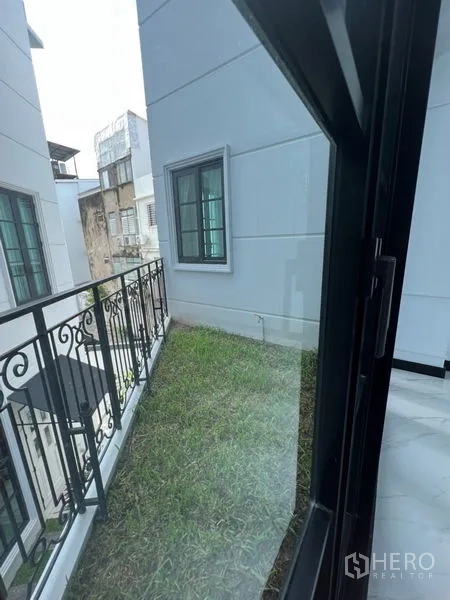 สำนักงานที่บ้าน ให้เช่าหรือขายในWatthana, Bangkok - ระเบียงสวนเล็กมีหญ้าอยู่ข้างตัวบ้าน พร้อมราวเหล็ก