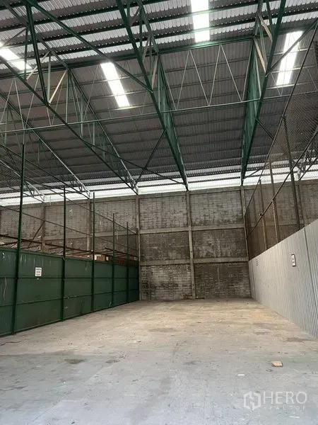 货栈 出租在Prawet, Bangkok - 高挑仓库空间，采光带与绿色钢梁，分隔储物区