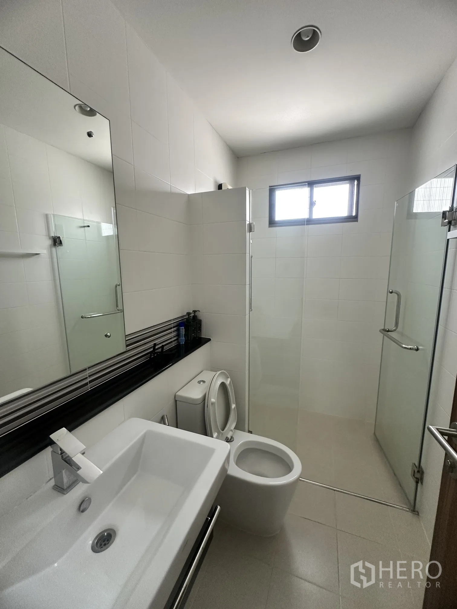 Detached House for sale in Pak Kret, Nonthaburi - Second bathroom with glass shower, modern sink, and small window.