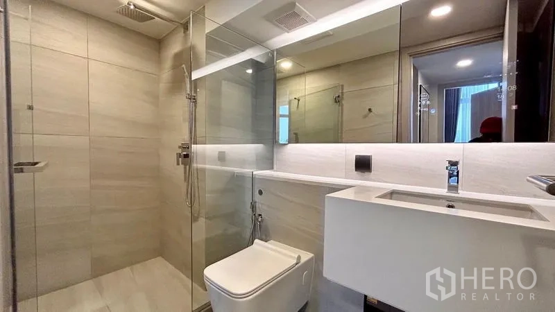 Condominium for rent - Contemporary bathroom with glass-enclosed rain shower, long vanity and large mirror.
