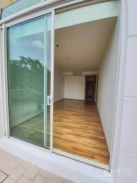 公寓 出租或出售在Sathon, Bangkok - 底层公寓房间，落地推拉门与木地板，连接花园露台景观。