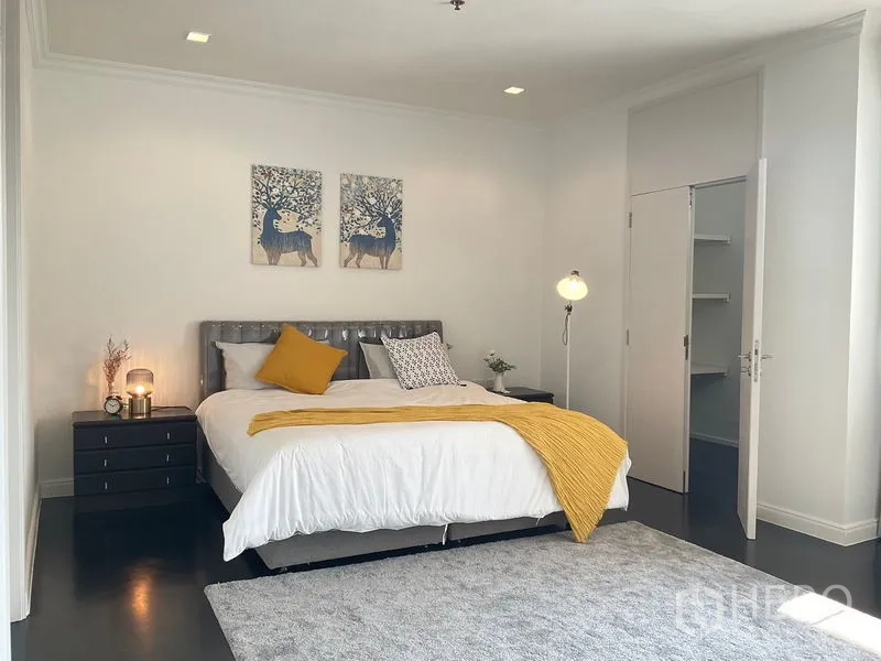 房间 出租在Sathon, Bangkok - 主卧配特大床、床头柜与衣帽间入口。