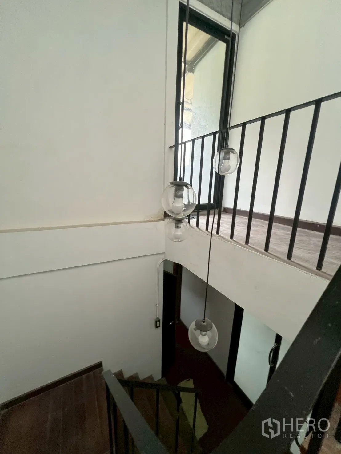 Home Office for rent in Watthana, Bangkok - Stairwell featuring hanging globe pendant lights and metal railings.