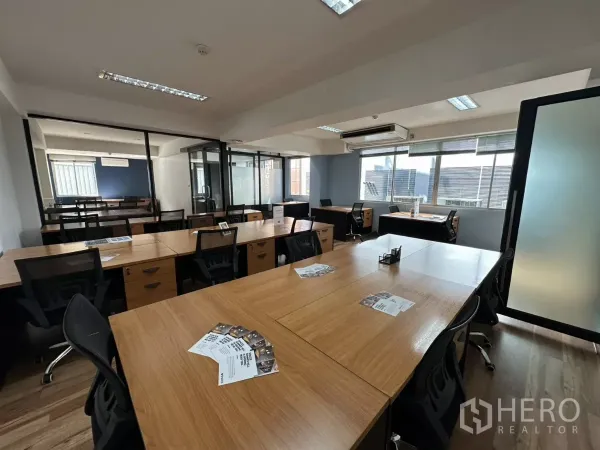 办公空间 出租在Watthana, Bangkok - 中央长桌对着玻璃隔断的私密房间与宽窗的现代办公室。