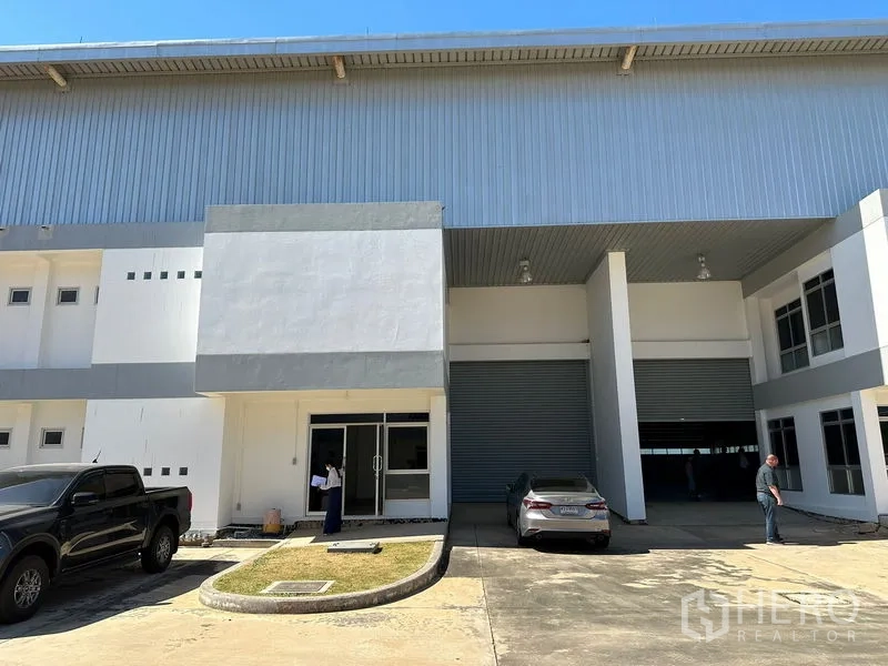 Factory for rent in Bang Bo, Samut Prakan - Factory front facade with covered loading bay, roller door and parking area.