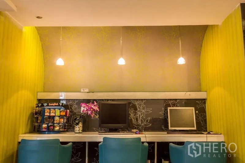 พื้นที่ขายปลีก ให้เช่า - มุมเวิร์กสเตชันพร้อมโคมไฟห้อย คอมพิวเตอร์ และตู้ขนม