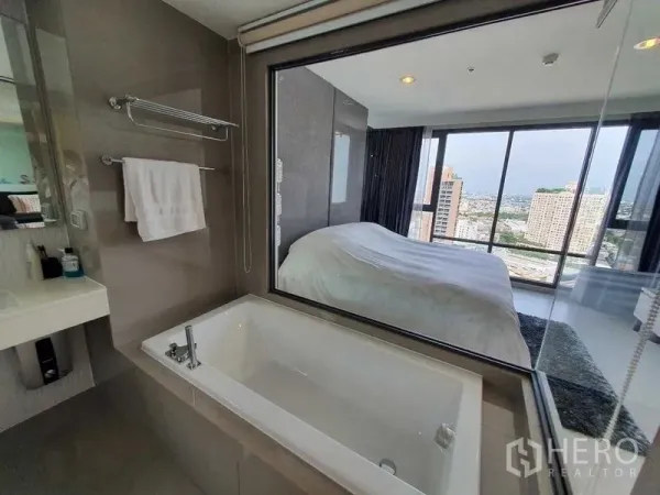 คอนโด ขายในKhlong Toei, Bangkok - ห้องน้ำในตัวพร้อมอ่างอาบน้ำและหน้าต่างเชื่อมถึงห้องนอน มองเห็นวิวเมือง