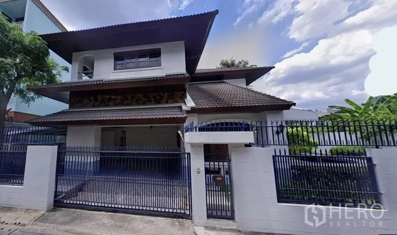 独立式住宅 出租在Watthana, Bangkok - 房屋正立面视图，带围栏与瓦屋顶。