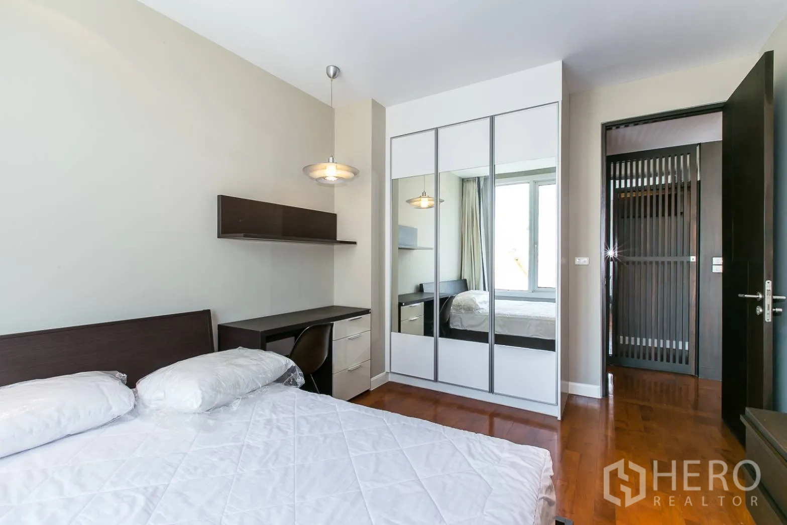 คอนโด ให้เช่าหรือขายในKhlong Toei, Bangkok - ห้องนอนรองพร้อมตู้เสื้อผ้าบานกระจก โต๊ะทำงาน และโคมไฟแขวน