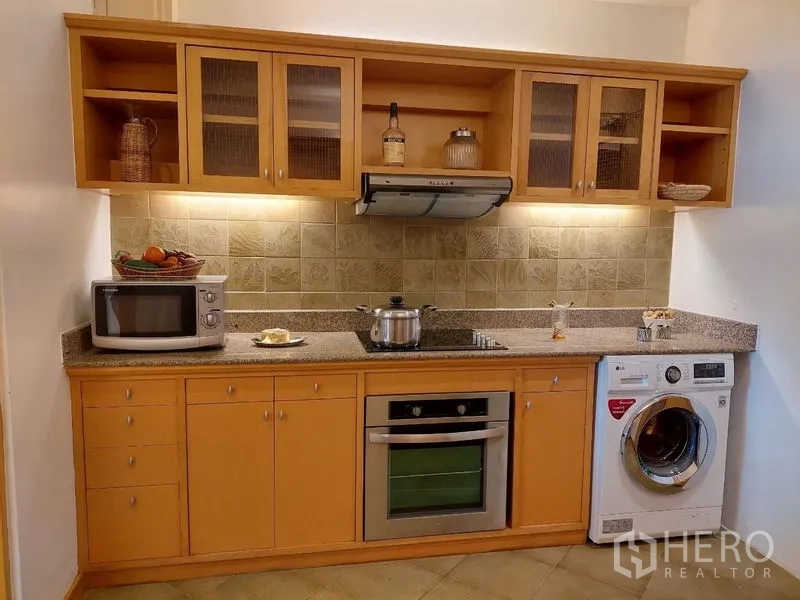 อพาร์ทเมนท์ ให้เช่า - ครัวบิวท์อินพร้อมเตาอบ เครื่องดูดควัน ตู้ลอย และเครื่องซักผ้า.