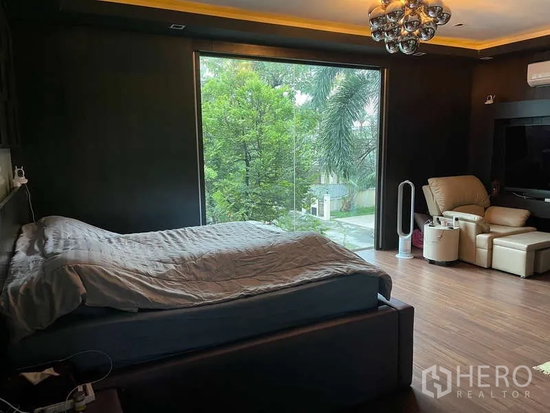 Detached House for sale in Suan Luang, Bangkok - Spacious master bedroom with floor-to-ceiling window overlooking lush trees.