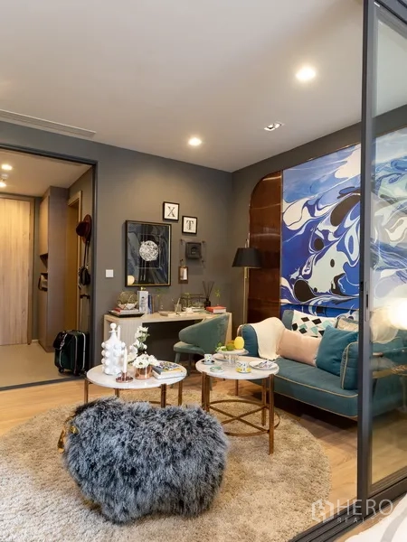 公寓 出售在Ratchathewi, Bangkok - 现代客厅，蓝绿色沙发与圆形茶几，艺术感背景墙。