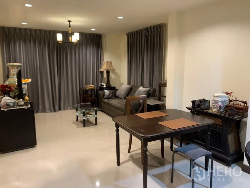 Detached House for rent in Khlong Sam Wa, Bangkok - Compact dining area with wooden table and chairs beside the living room.