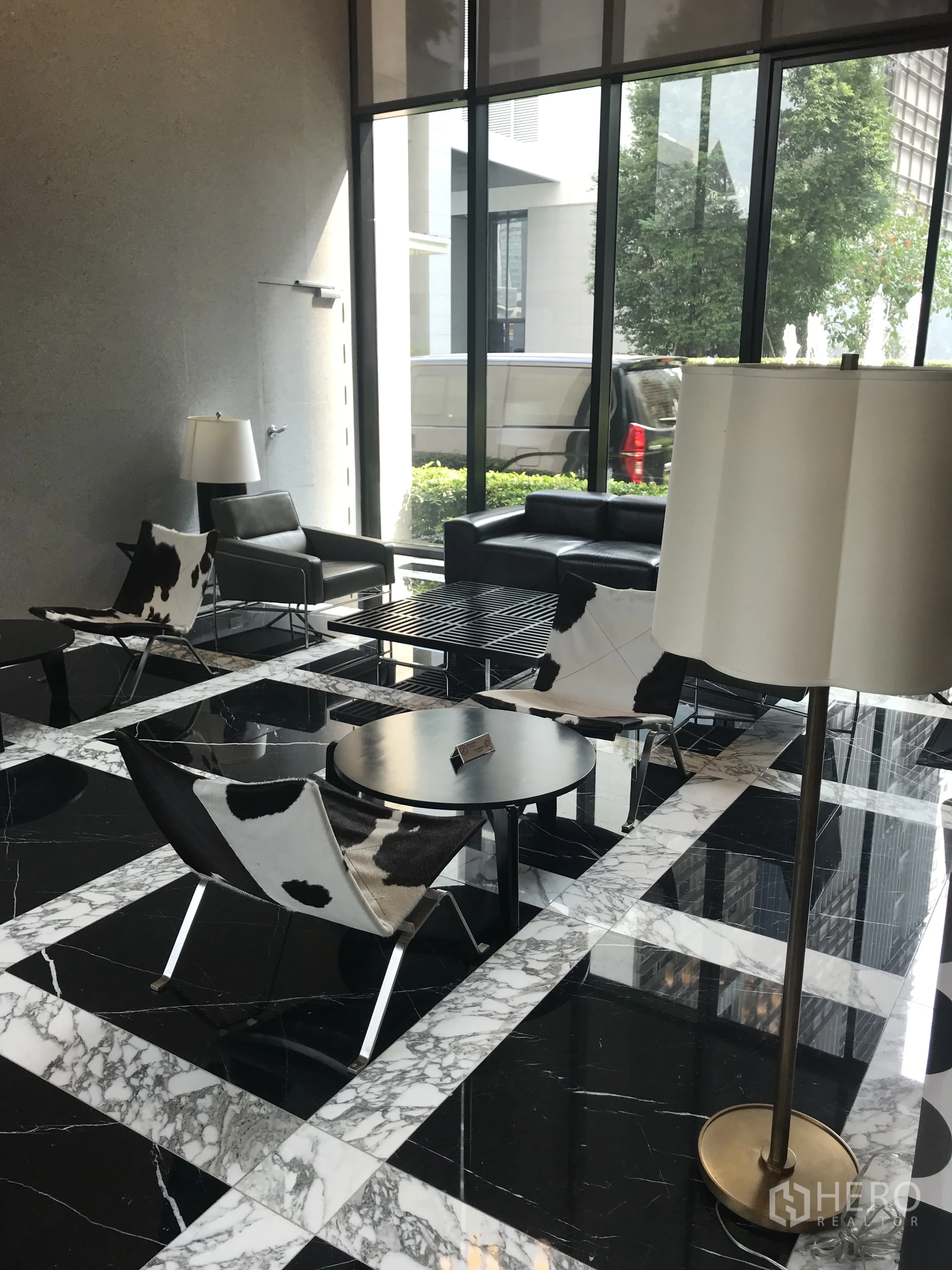 Condominium for sale in Khlong Toei, Bangkok - Stylish lobby with marble floors, modern seating, and tall glass windows.