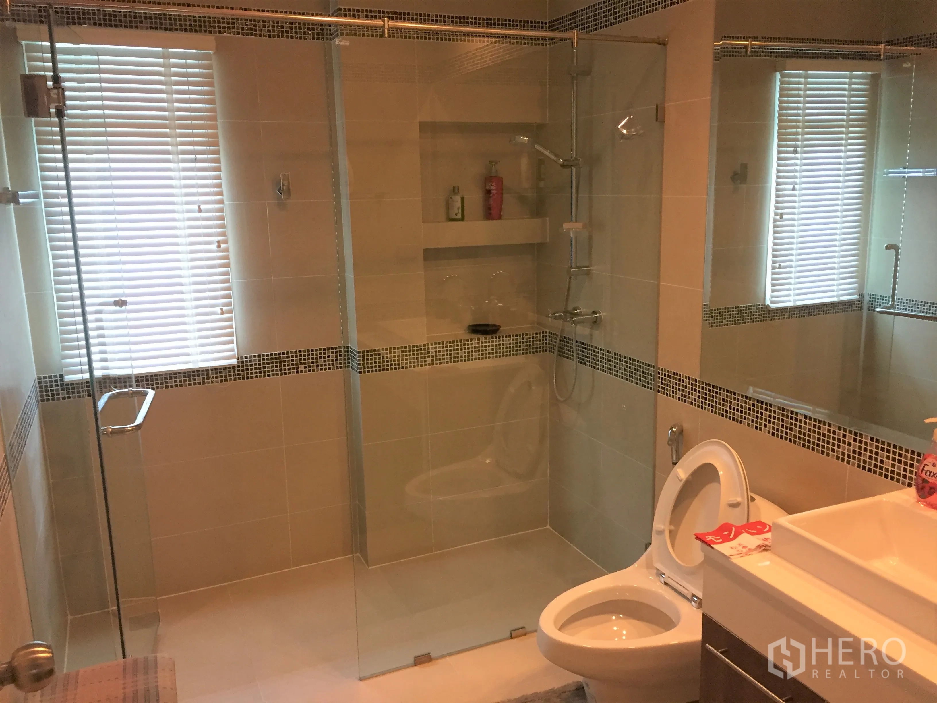 Detached House for rent in Saphan Sung, Bangkok - Modern bathroom with glass-enclosed shower, vanity and toilet.
