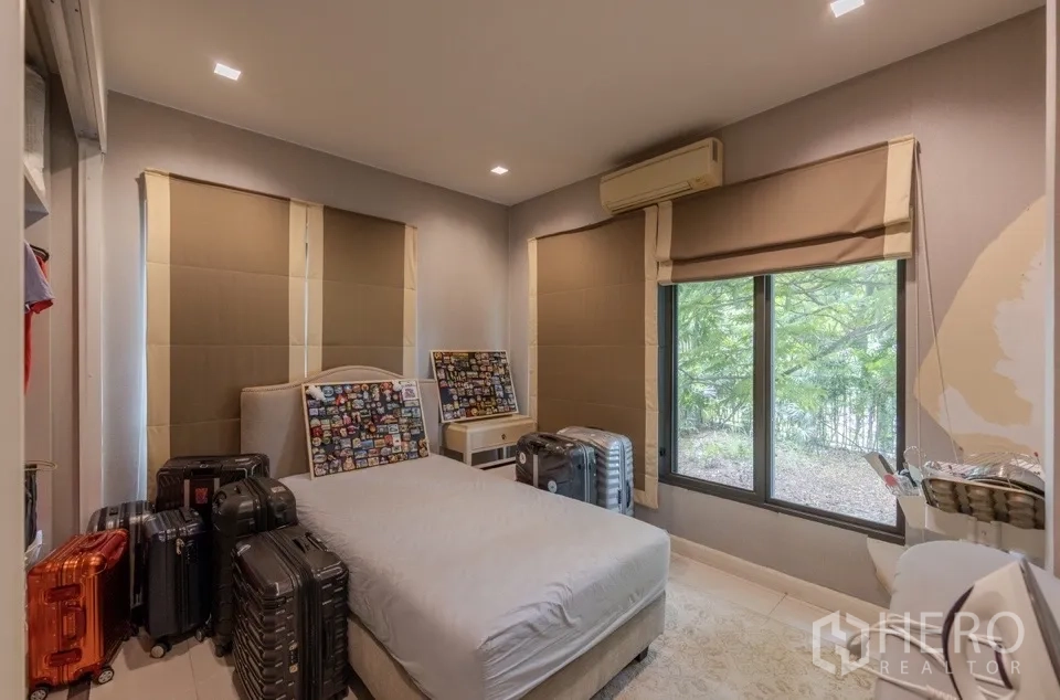 Detached House for rent or sale in Bang Kapi, Bangkok - Bright bedroom with large windows and roller blinds.