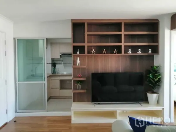 公寓 出售在Yan Nawa, Bangkok - 电视特色墙与开放式搁架，旁为通往厨房的推拉玻璃门。