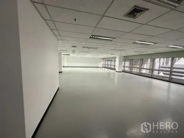 สำนักงาน ให้เช่า - พื้นที่สำนักงานแบบเปิดโล่ง เพดานฝ้าพร้อมไฟ และหน้าต่างยาวตลอดแนว.