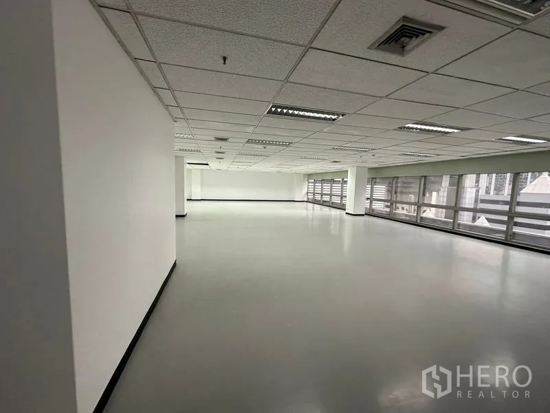 สำนักงาน ให้เช่า - พื้นที่สำนักงานแบบเปิดโล่ง เพดานฝ้าพร้อมไฟ และหน้าต่างยาวตลอดแนว.